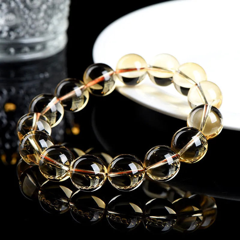 Natural citrine scattered beads ball bracelet showing polished stones in yellow-amber hues on a white background.