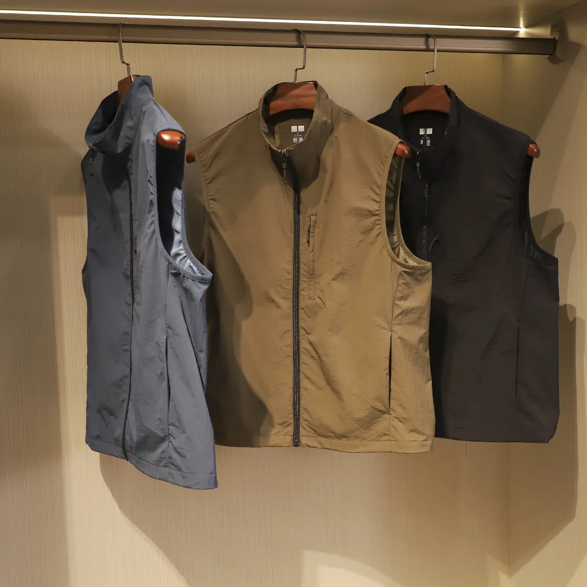 Men's straight cut nylon vest in army green with side seam pockets.