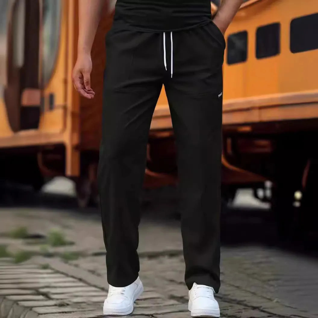 Men's polyester trousers in light grey, shown laid flat, suitable for spring and autumn wear.