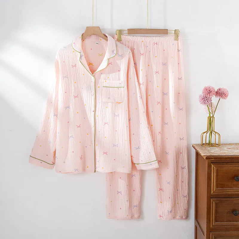 Women's thin cotton long-sleeved pajama set in pink, showing top and trousers laid flat.