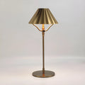 Gold alloy desk lamp with a fabric shade on a wooden table