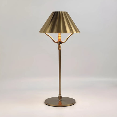 Gold alloy desk lamp with a fabric shade on a wooden table