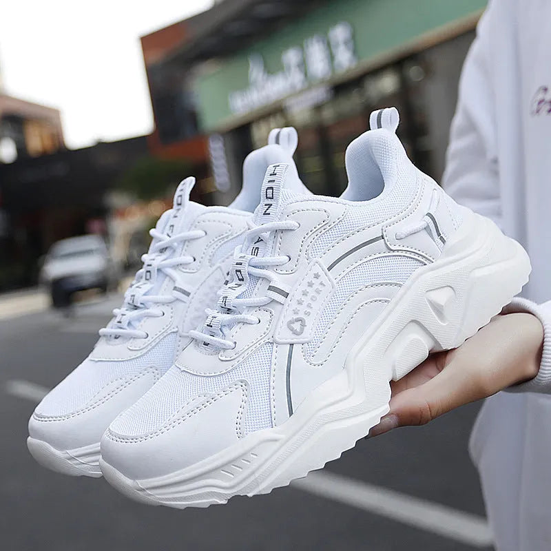 Women's white thick-soled casual sports shoes with mesh upper and buckle detail.