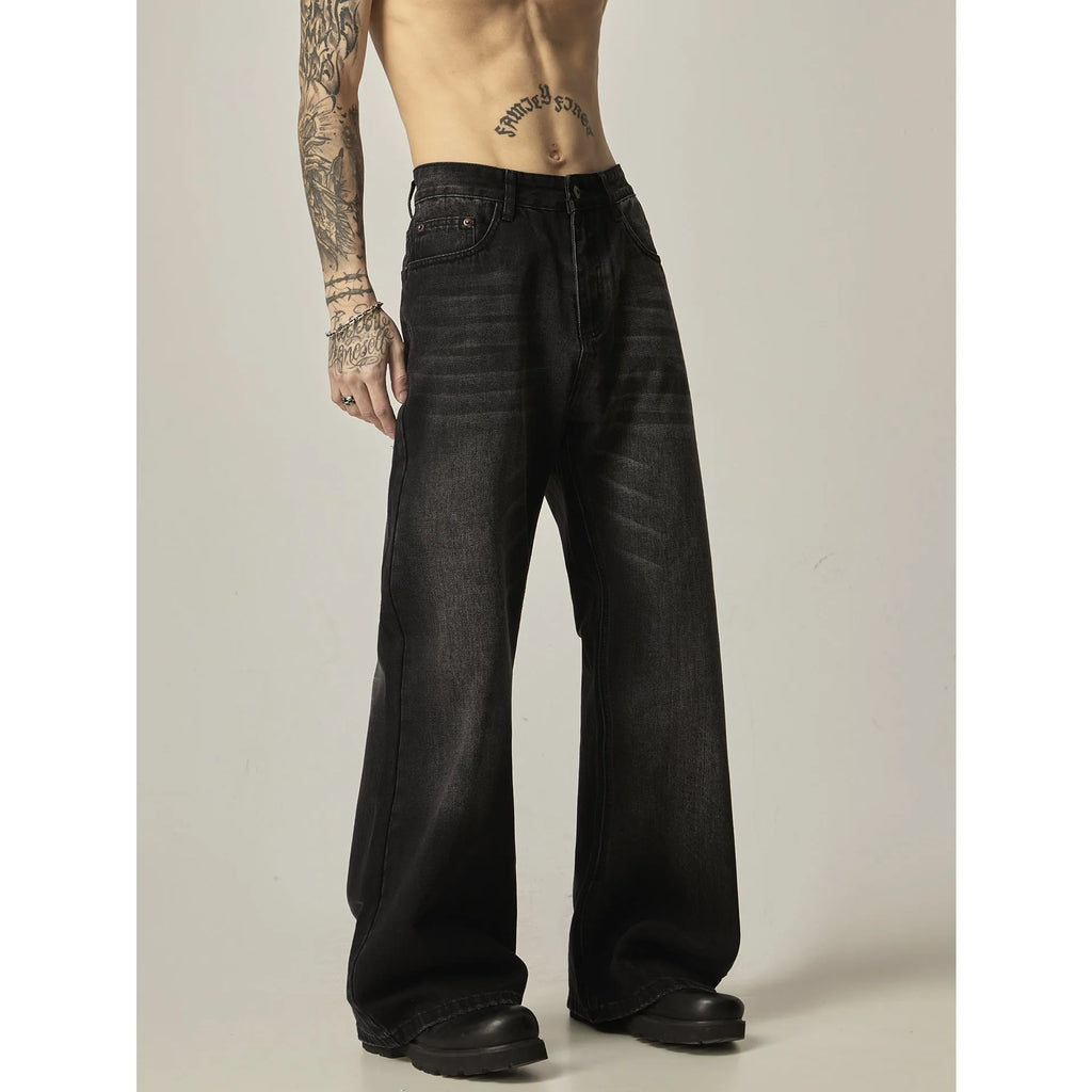 Man wearing black loose-fit straight-leg retro jeans in a casual setting.