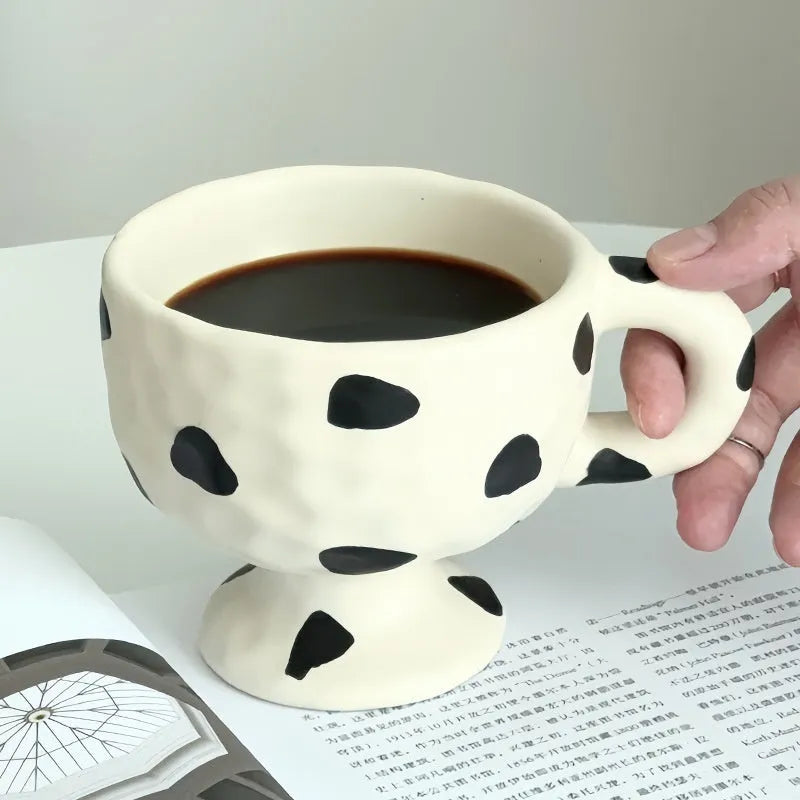 Hand-pinched irregular shaped ceramic mug in a solid colour, shown from the side.