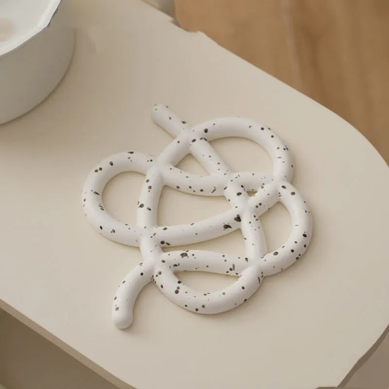 Ceramic heat proof mat in irregular shape on dining table surface