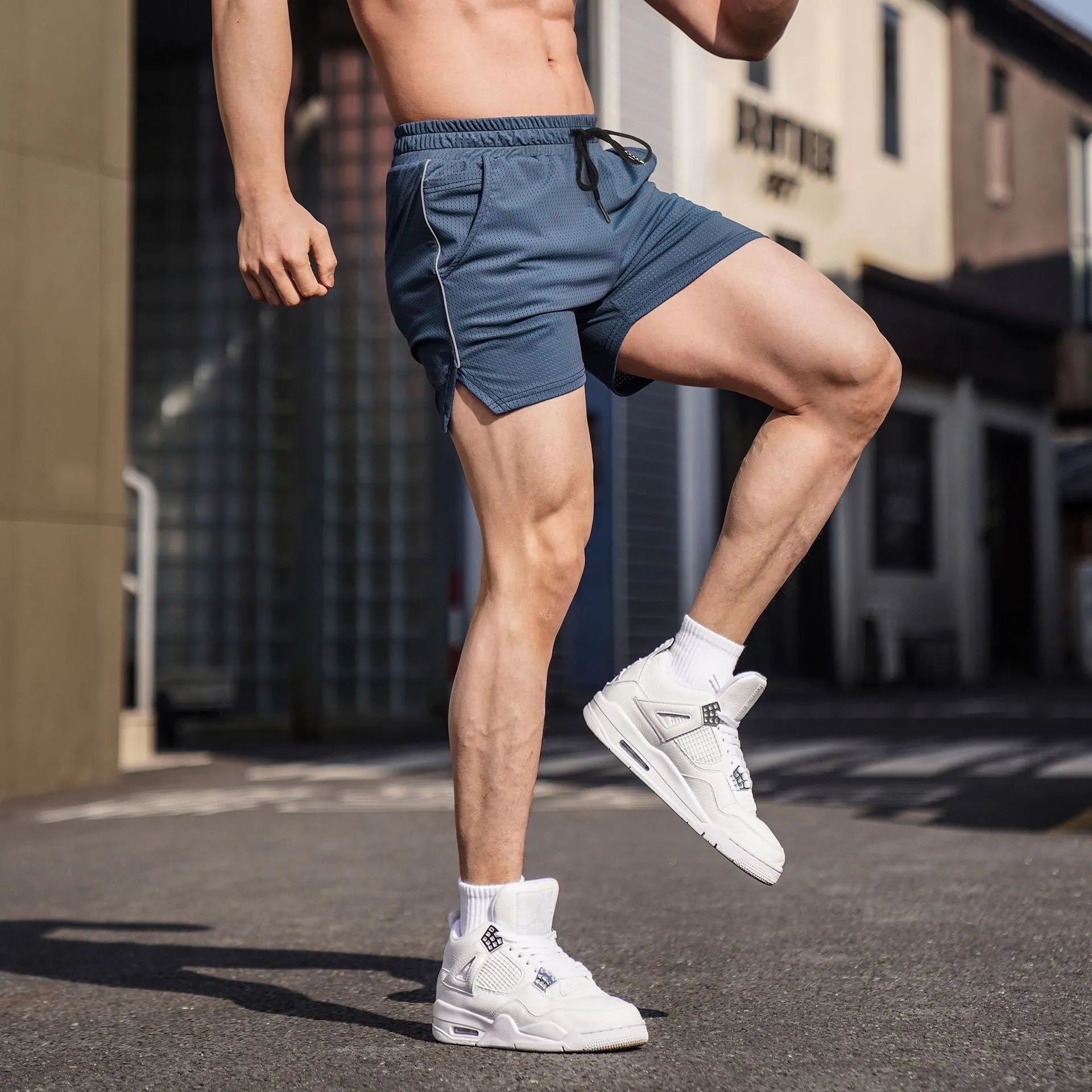 Men's black polyester straight-leg sports shorts on a hanger, showing the athletic cut and shorts length.