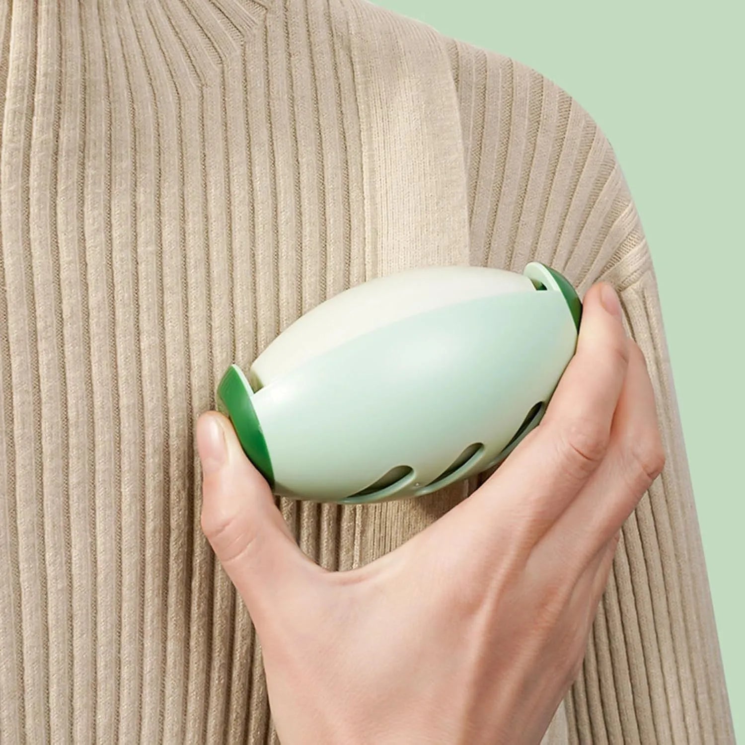 Green and white reusable gel lint roller ball for portable pet hair removal.
