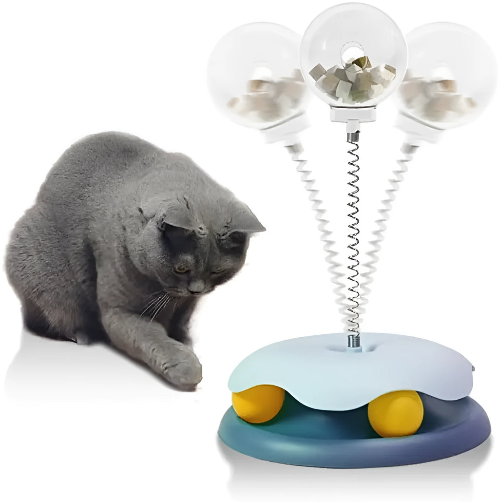Blue and green cat treat dispenser toy with track ball on a wooden floor
