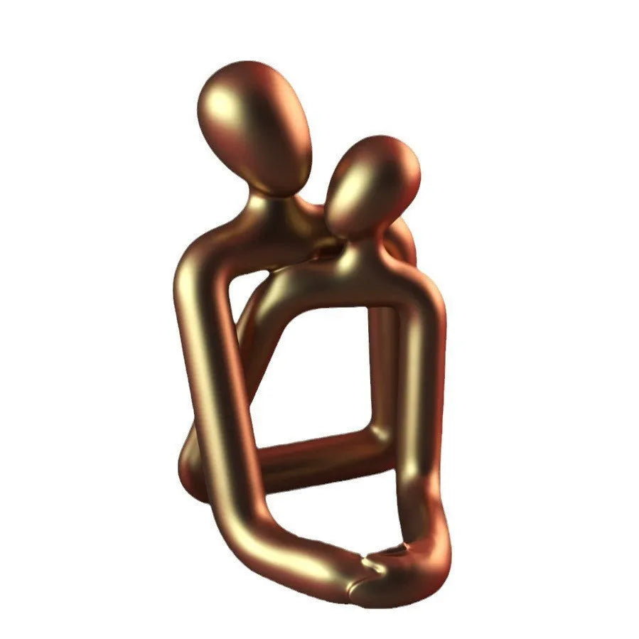 Modern minimalist loving couple resin statue in Gold or Milky White finish on a wooden surface.