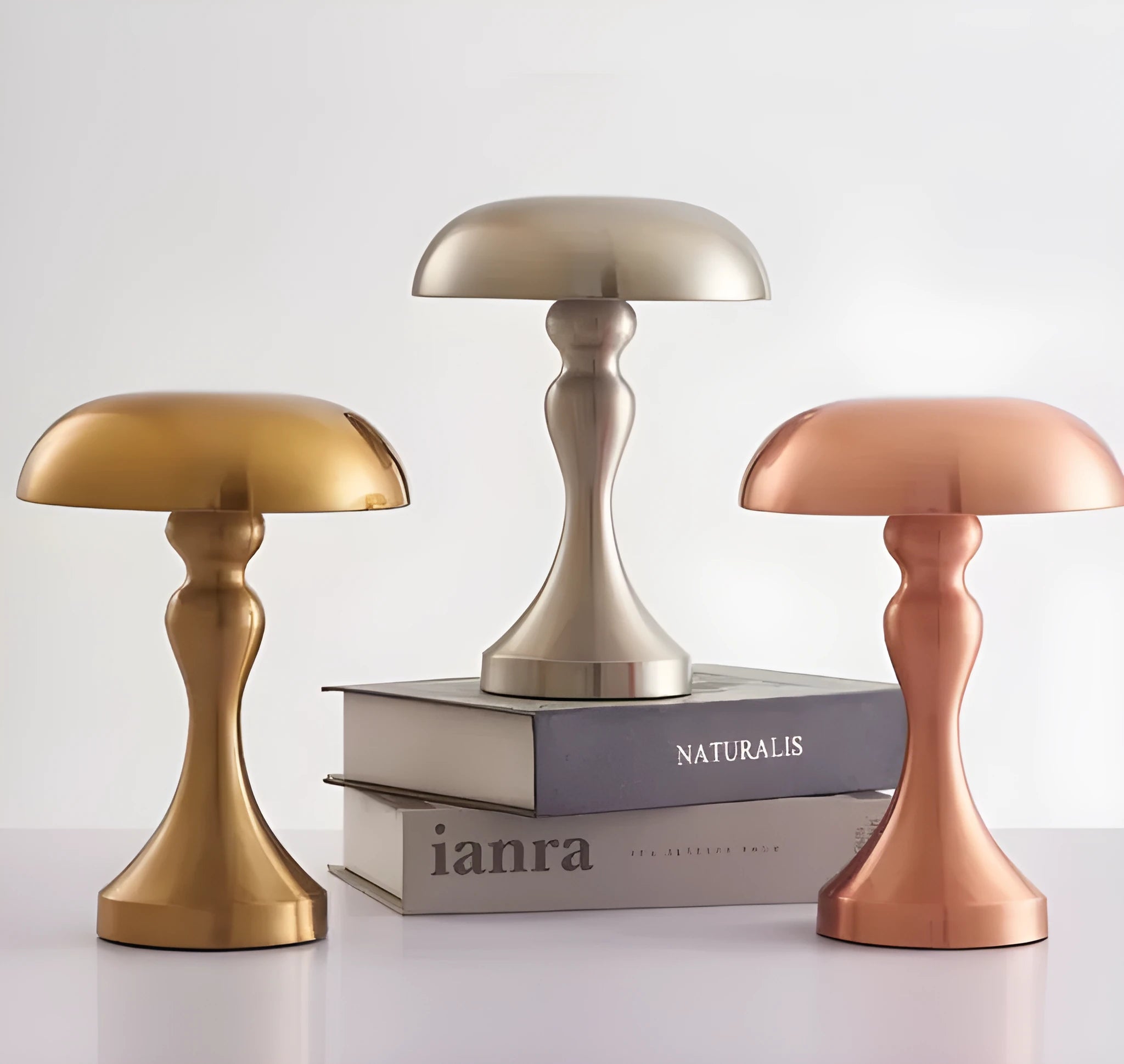 Metallic USB-rechargeable LED desk lamp with touch control for three light colours on a wooden desk.