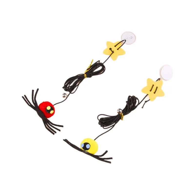 Red door hanging cat toy with elastic rope, feather, bell, and spider attachment on a white door.