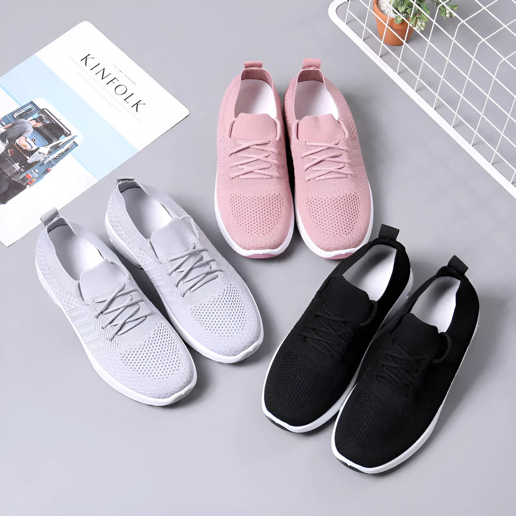 Women's black mesh casual sneakers with round toe and white lace-up front on a grey PVC sole.