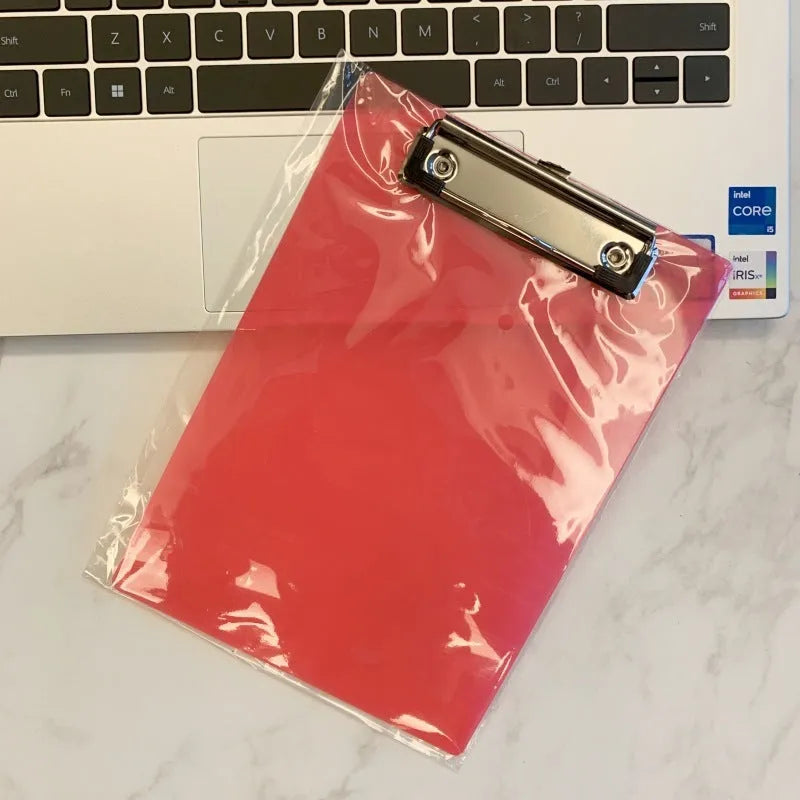 A4 transparent plastic writing board pad with metal clip in blue colour on a desk