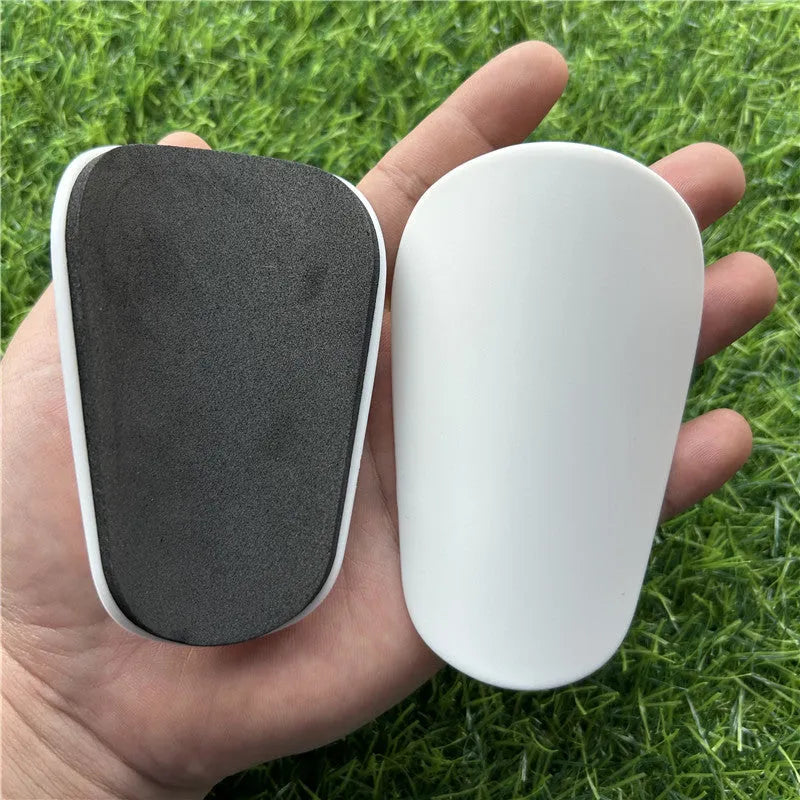 Extra small 8x5cm plastic football shin guards in black and white colours