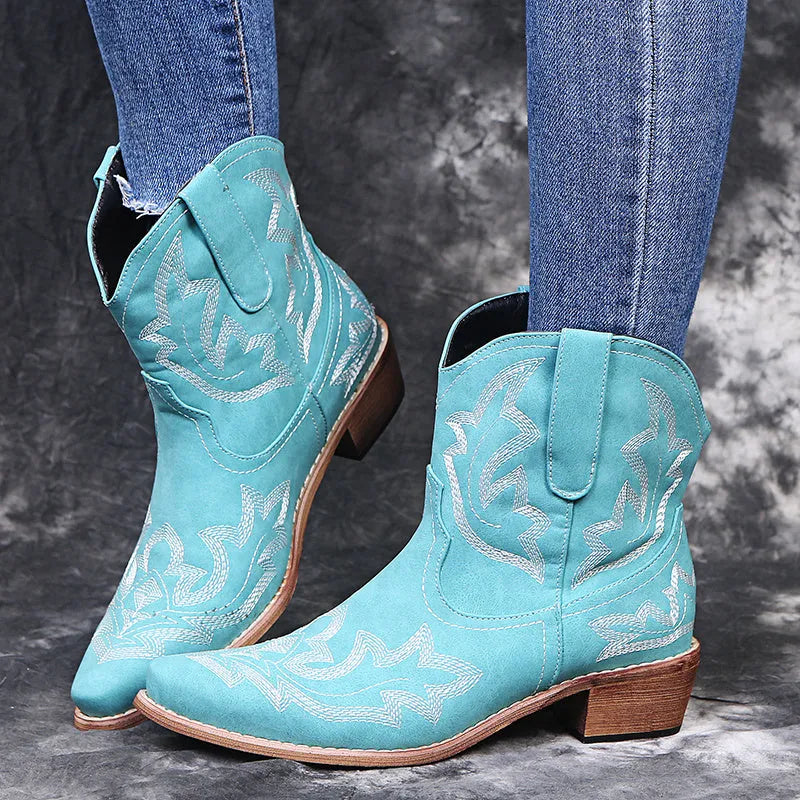 Blue women's cowboy boots with floral embroidery, a wedge heel, and a pointed toe.