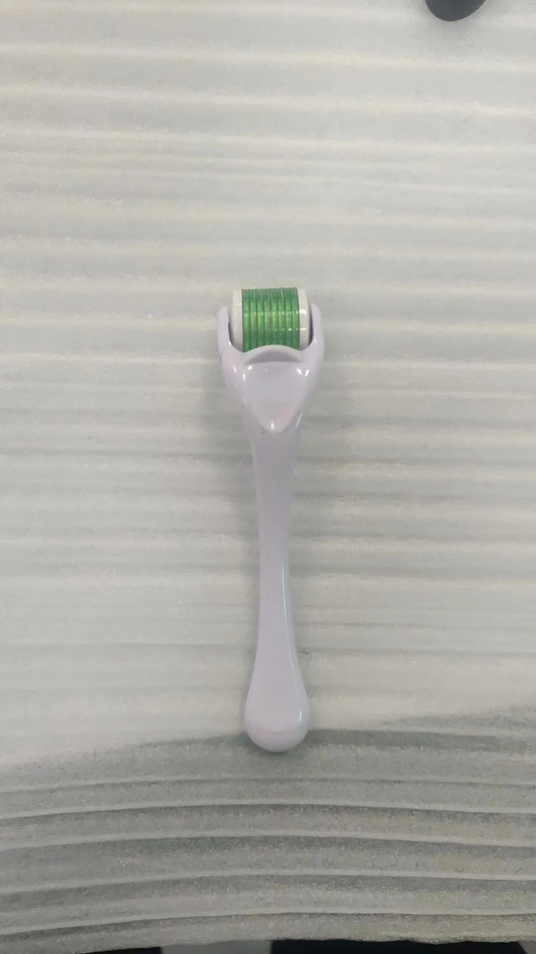 Black handle micro needle roller with purple wheel showing 540 stainless steel needles for dermaplaning