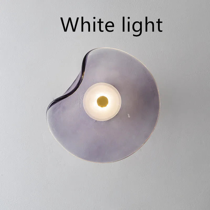 Round glass wall lamp for bedroom bedside in cognac, grey or light colour finishes.