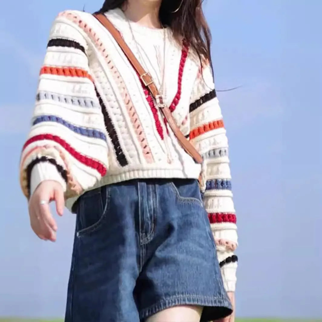 Colourful rainbow striped loose knit sweater with batwing sleeves and a round neck.