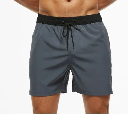 Men's blue drawstring shorts with a zippered pocket and stitching waist detail