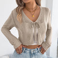 Women's khaki lace-up coat with hollow-out detail and long sleeves.