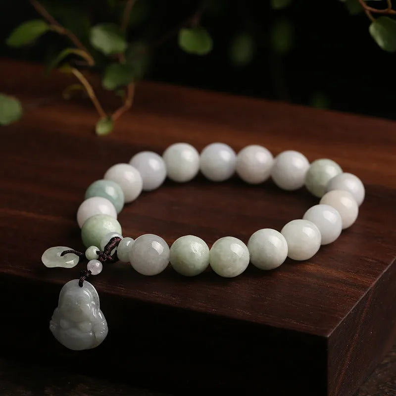 Natural green jade bracelet with a geometric pendant charm on a wrist.