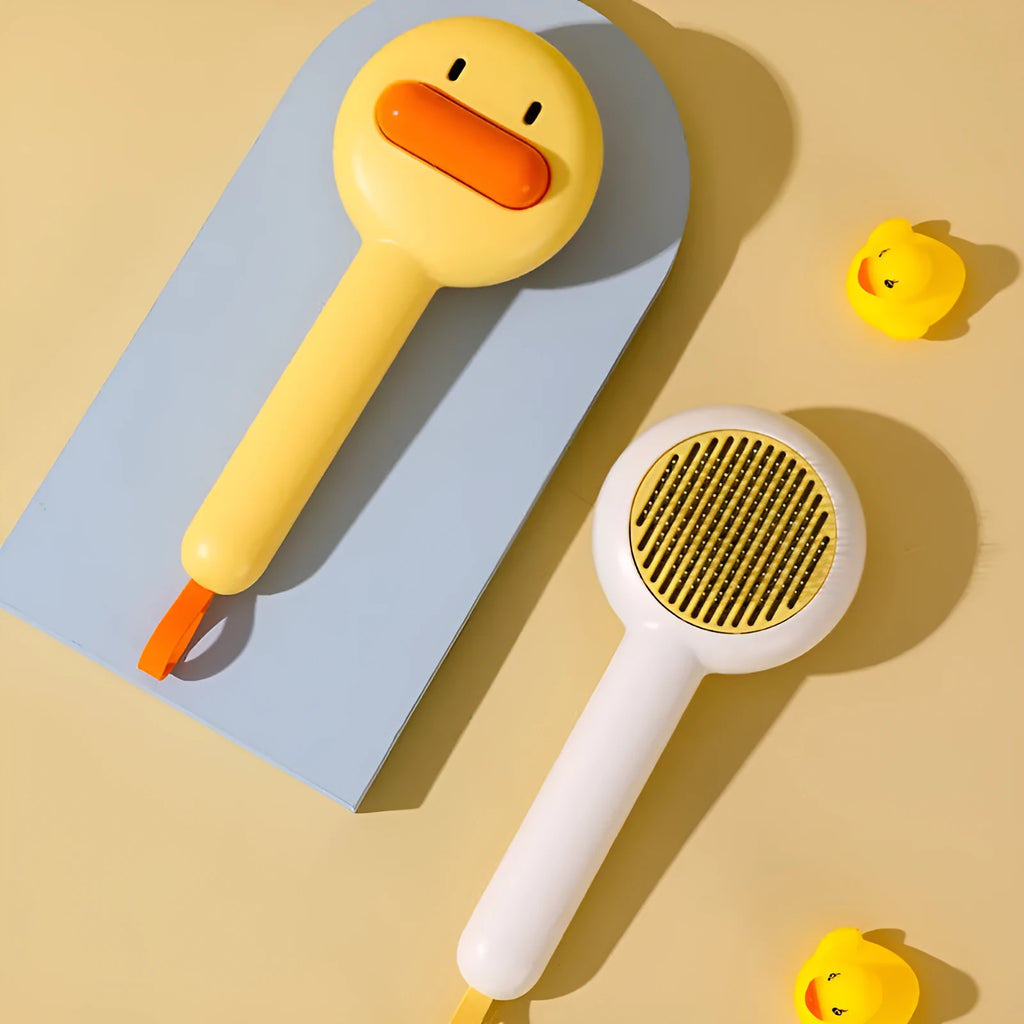 Small yellow duck-shaped pet grooming comb with needle pins for cats and small dogs