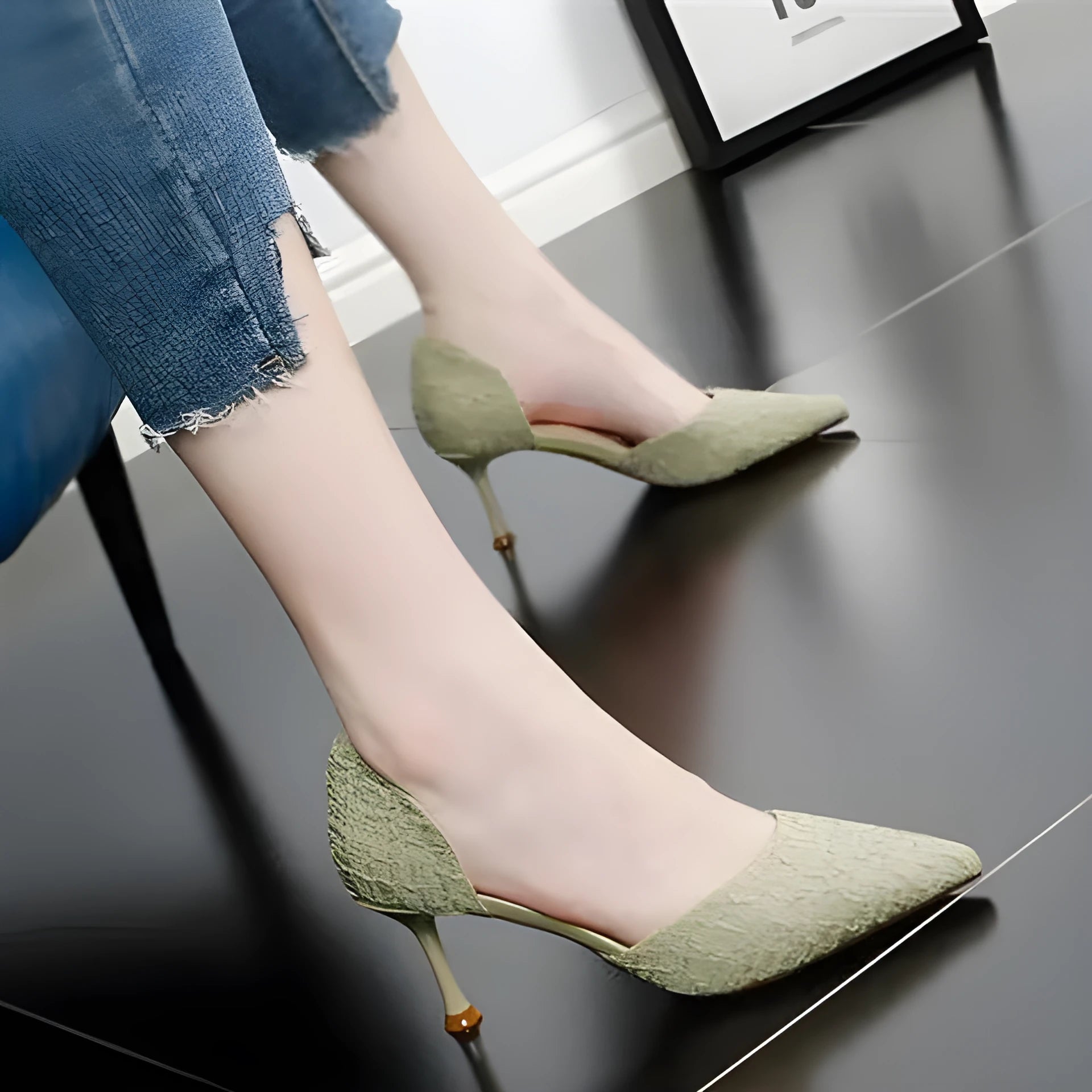 Women's black pointed toe stiletto sandals with a high heel on a plain background.