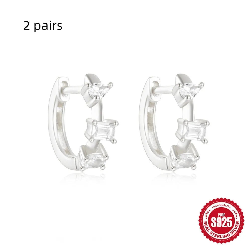 Sterling silver geometric stud earrings with a small round shape and classic diamond detail on a white background.
