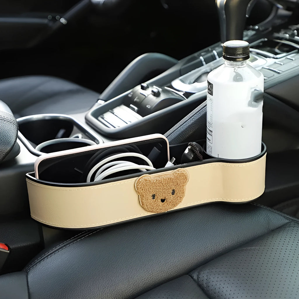 Leather car seat gap storage box with a cartoon bear design hanging between vehicle seats.