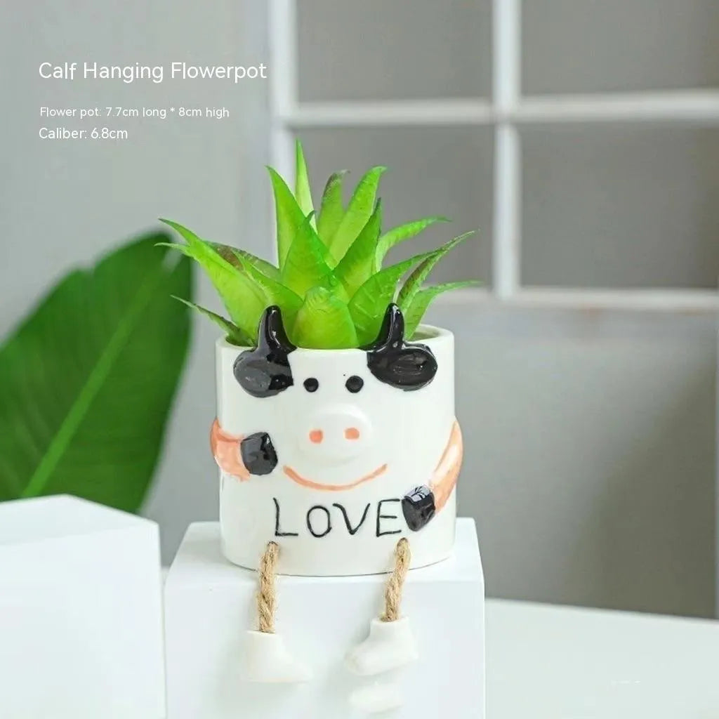 Cartoon style ceramic hanging foot flowerpot for succulent plants on a desktop.