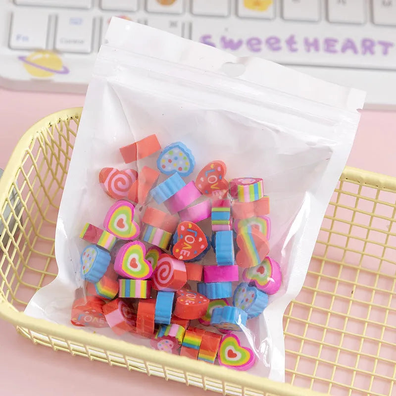 50 small colourful cartoon erasers in a pearlescent bag showing fruit, animal, cake, and Halloween themes.