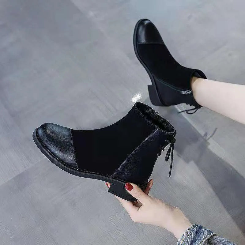 Black women's knee-high Martin boots with a bow detail and side zip on a rubber sole.