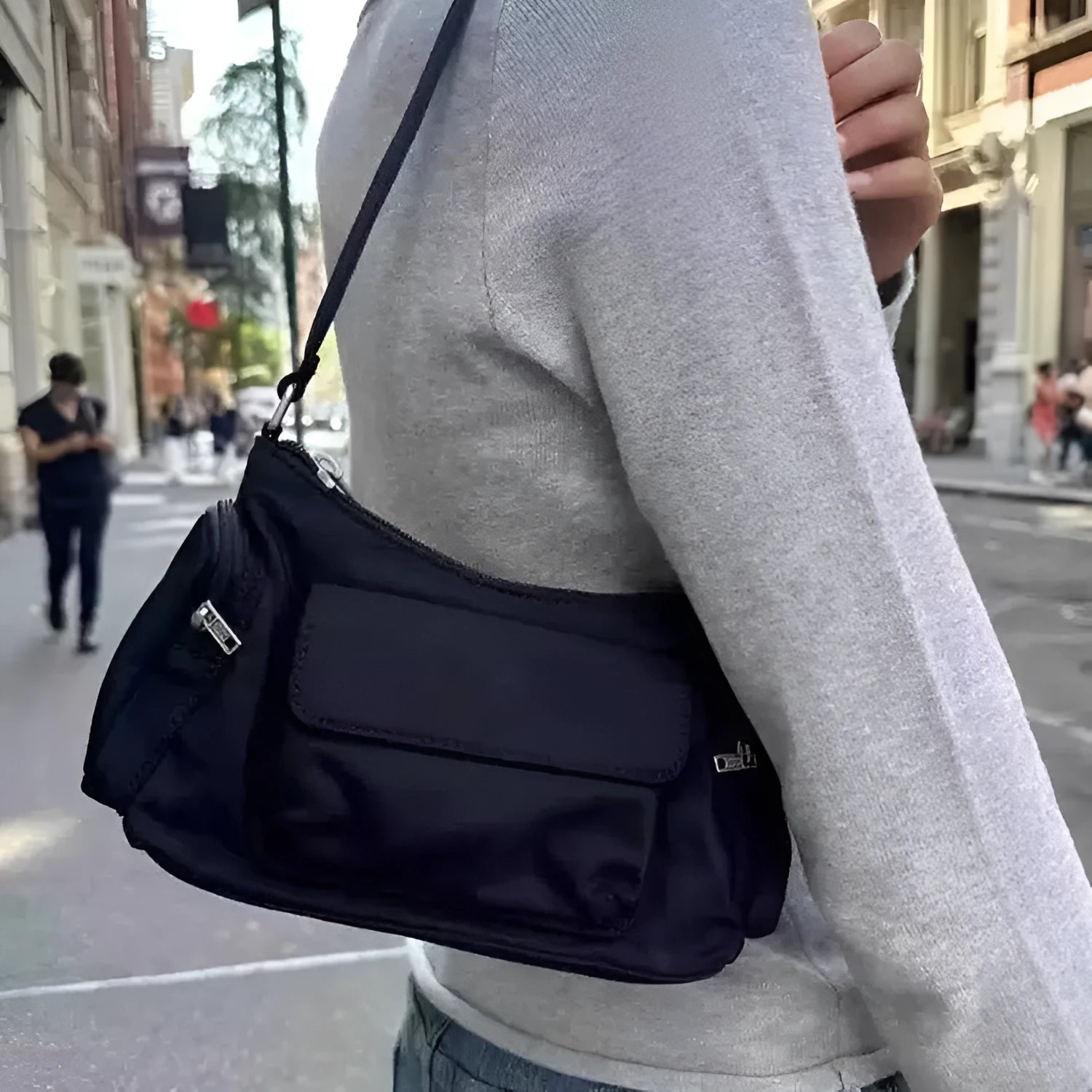Black women's shoulder bag with two front pockets showing side line stitching detail
