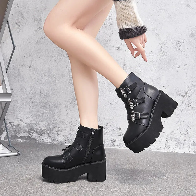 Black women's punk style ankle boots with bat buckle and side zip.