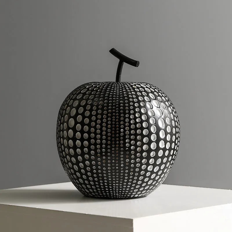 Resin decorative sculptures of apples and pears in black, white, orange and blue colours.