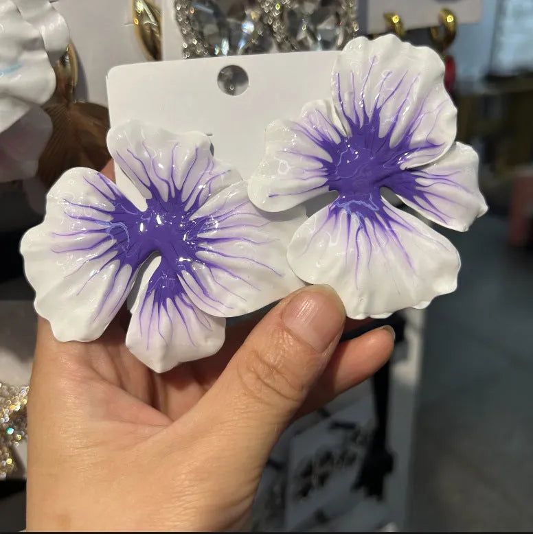 Close-up of alloy floral stud earrings with oil-spot glaze in blue, green, purple, and rose colour options.