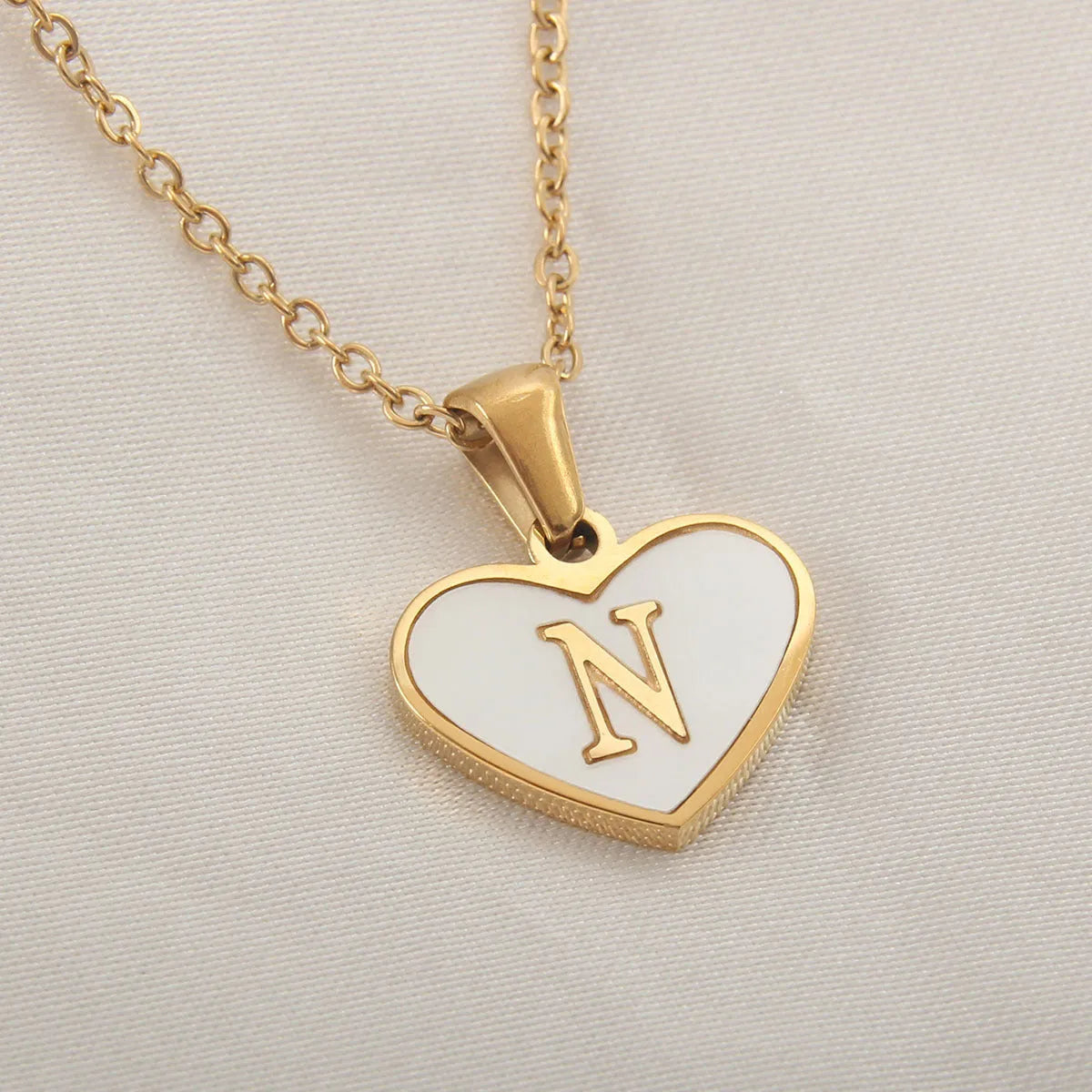 Gold plated heart-shaped personalised necklace with white shell charm on an adjustable chain.
