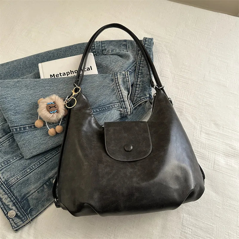 Women's textured PU leather shoulder bag with single strap and mobile phone compartment in black colour
