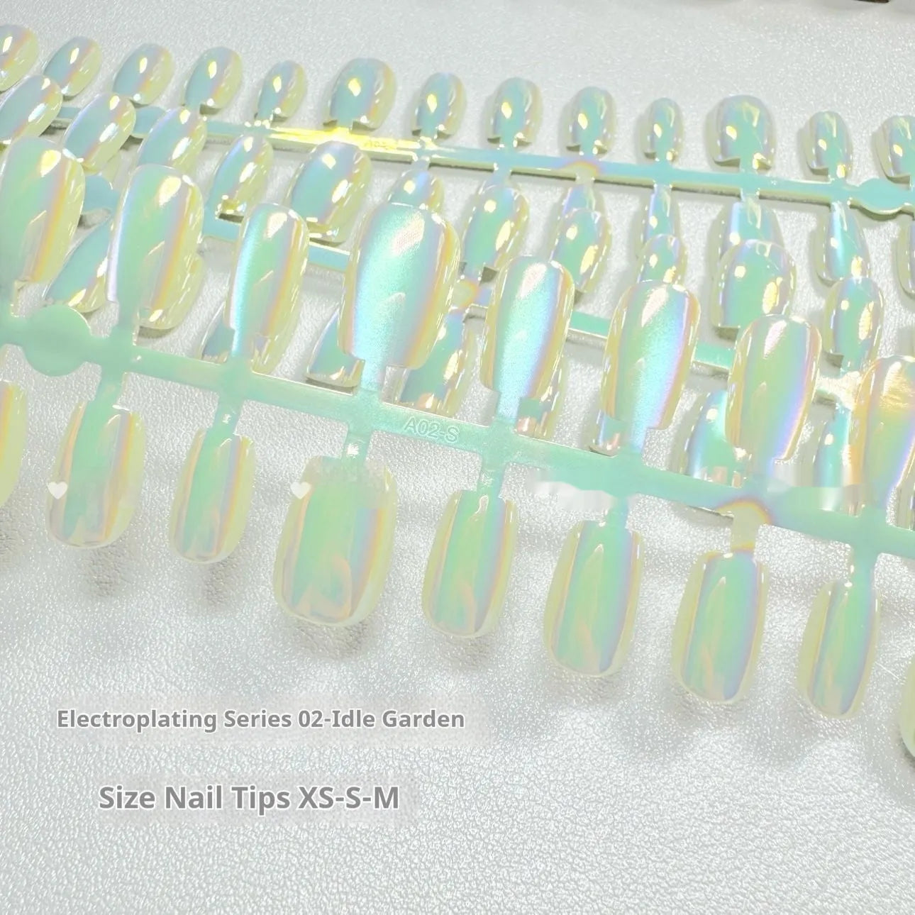 Electroplated cat's eye false nails with aurora colours in short ladder lengths on a hand.