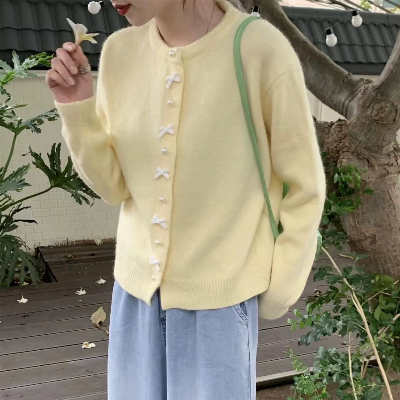 Women's solid colour cardigan sweater with pearl buttons in a light blue shade, shown open.