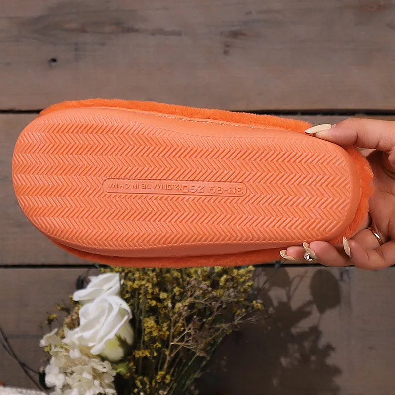 Orange Halloween pumpkin themed slippers with coral velvet upper and plush lining on a flat PVC sole.