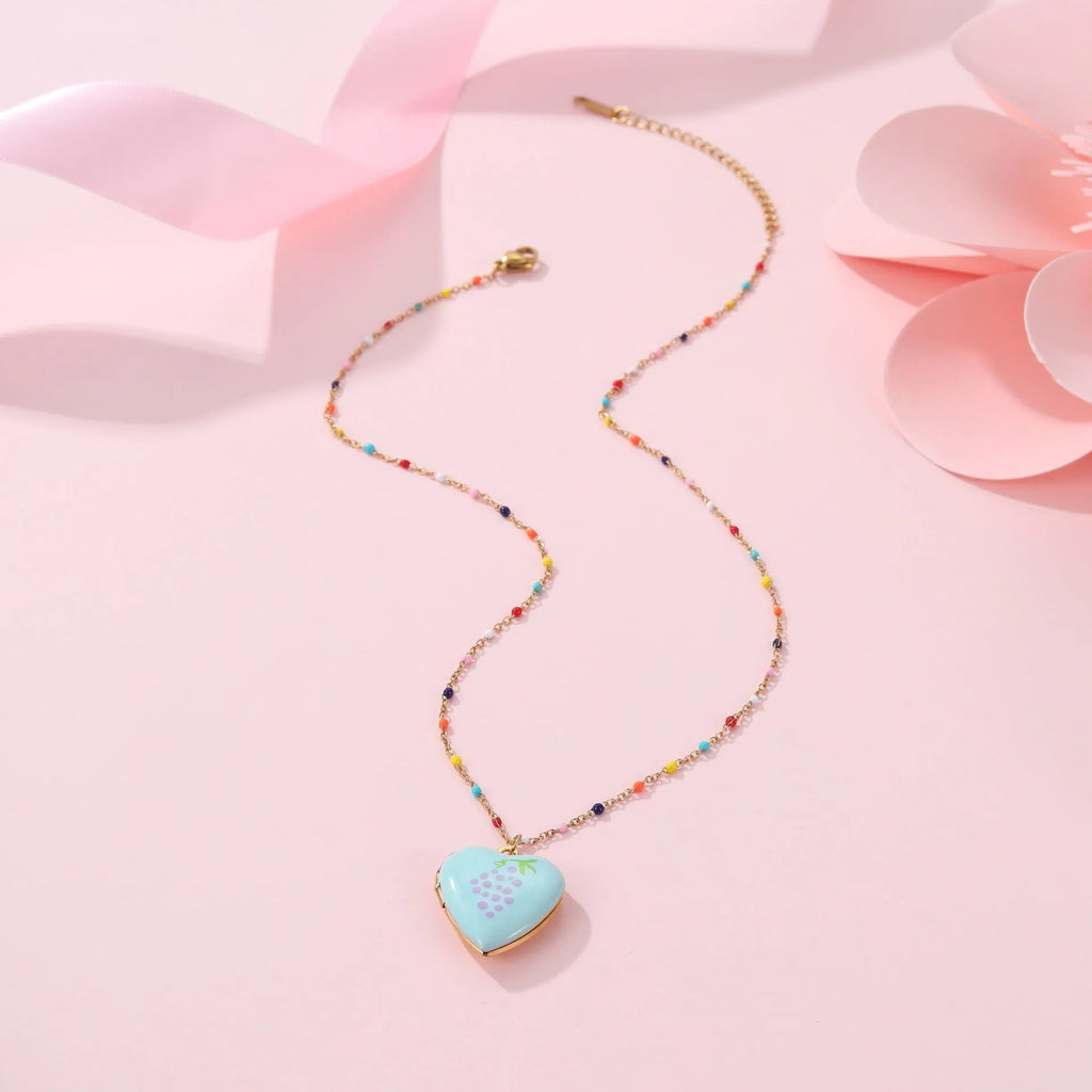 Women's stainless steel necklace with 18K gold plating showing heart pendant with fruit designs