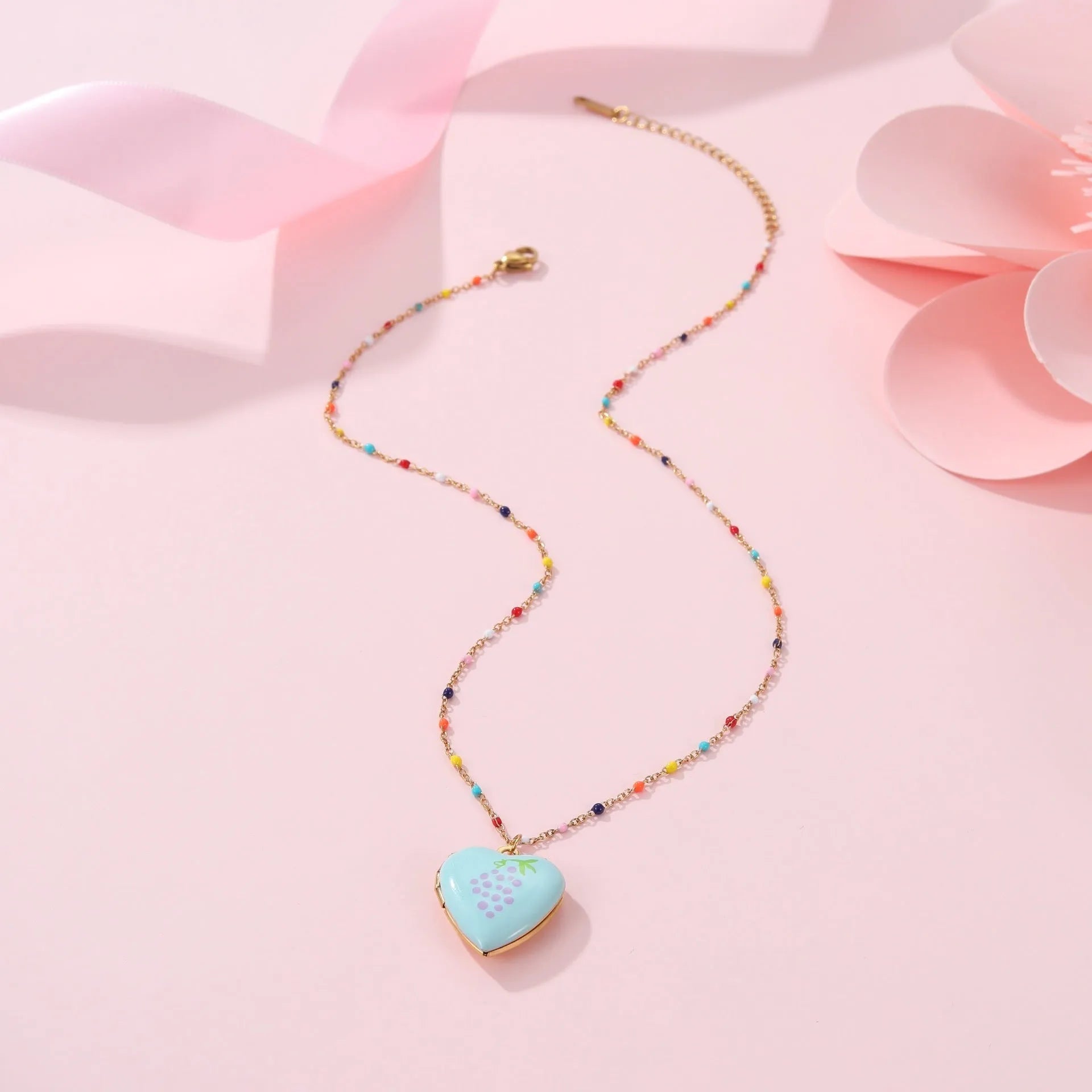 Women's stainless steel necklace with 18K gold plating showing heart pendant with fruit designs