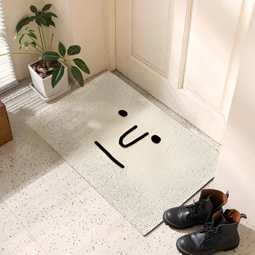 Square PVC floor mat with a large cartoon face and geometric pattern in Mr. Big Nose colours on a home floor.