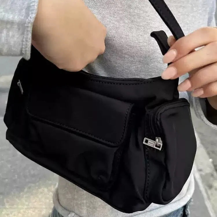 Black women's shoulder bag with two front pockets showing side line stitching detail