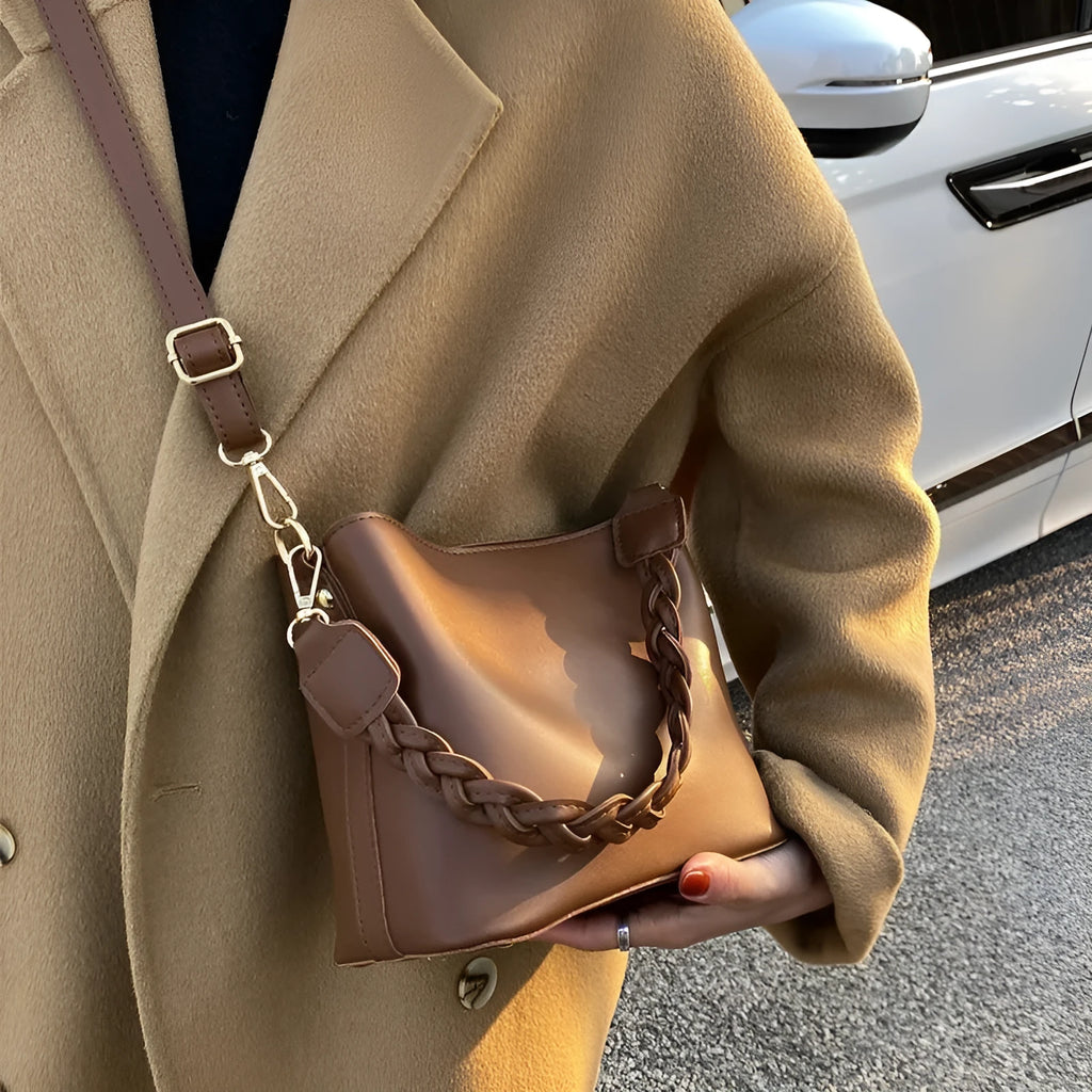 Khaki PU leather crossbody bucket bag with weaving texture and single shoulder strap.