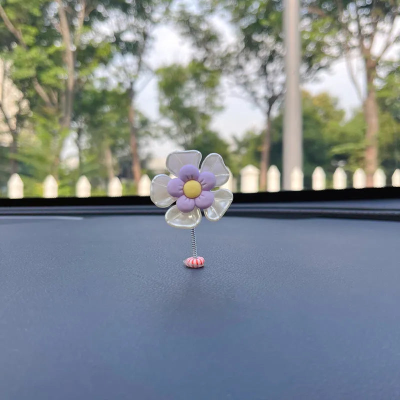Small colourful plastic car swing decoration hanging from a rear-view mirror.