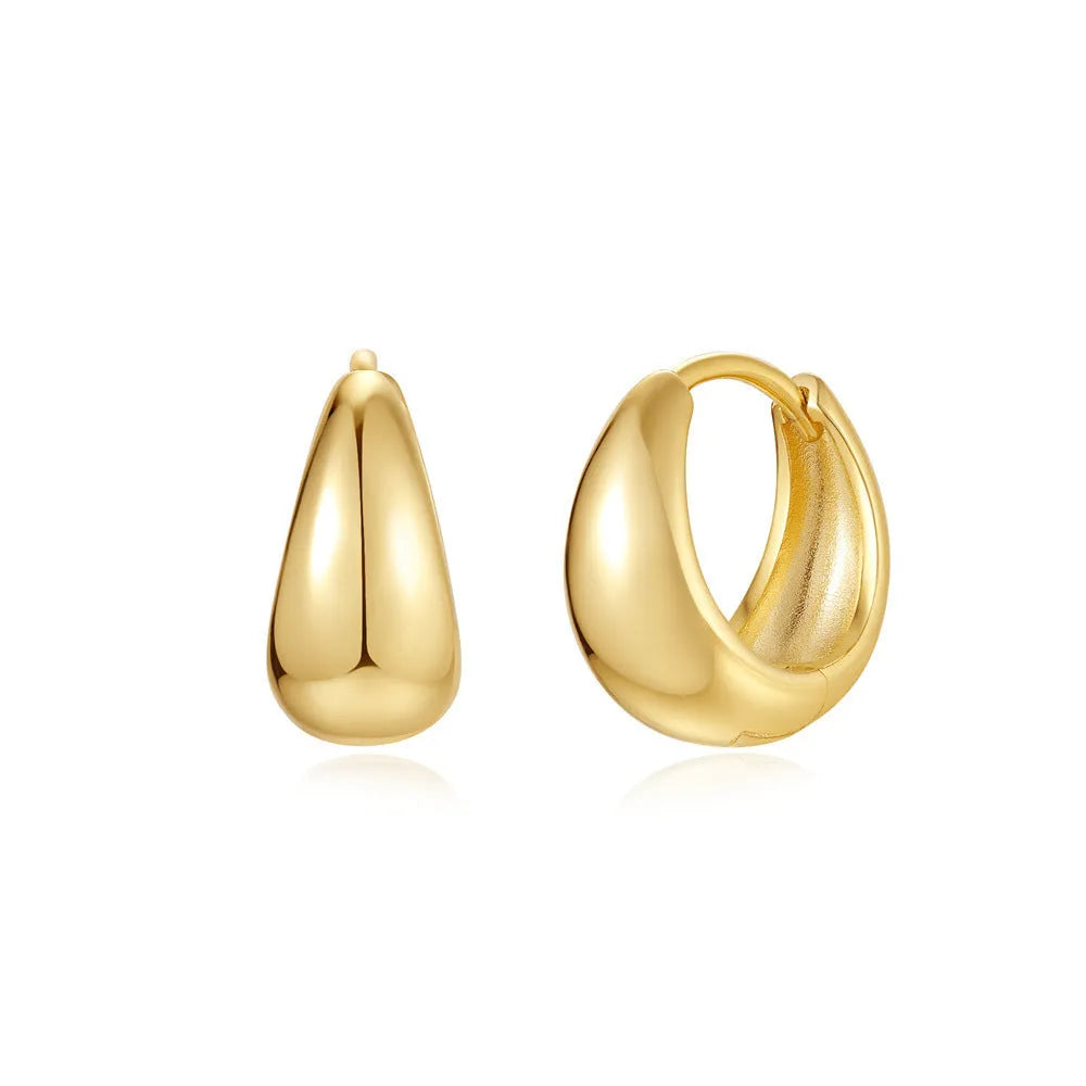 A pair of simple geometric brass earclip earrings with a round element and electroplated golden finish.