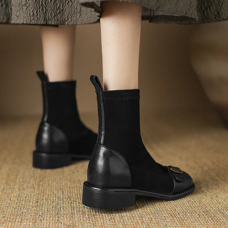 Black women's low heel Martin boot with belt buckle stitching and lace-up front on a rubber sole.